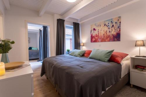 a bedroom with a bed and a painting on the wall at Weberhof Ferienapartments in Rostrup am Westufer des Zwischenahner Meers in Bad Zwischenahn