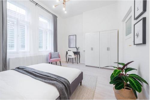 a white bedroom with a bed and a table at APTs in OLD TOWN PRAGUE by Michal&Friends in Prague