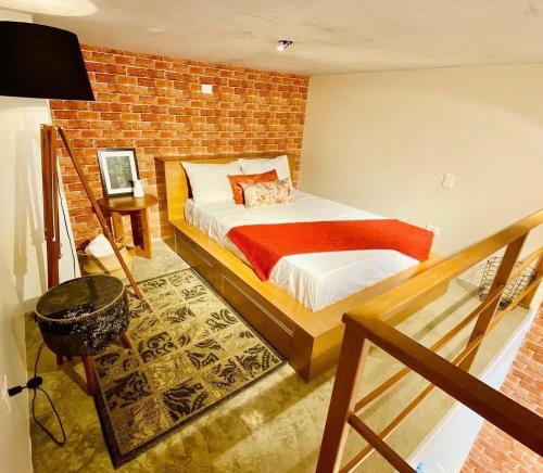 um quarto com uma cama e uma parede de tijolos em LOFT46 EM De MARILIA em Marília
