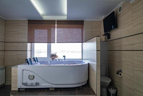 a white tub in a bathroom with a window at Kodatskiy Kosh in Dnipro