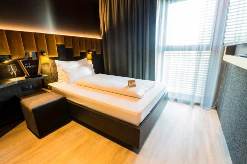 a hotel room with a bed and a window at MY HOME MY HOTEL Rosenheim in Rosenheim