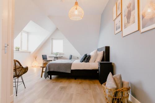 a bedroom with a bed and a chair at Millsight in Uitgeest