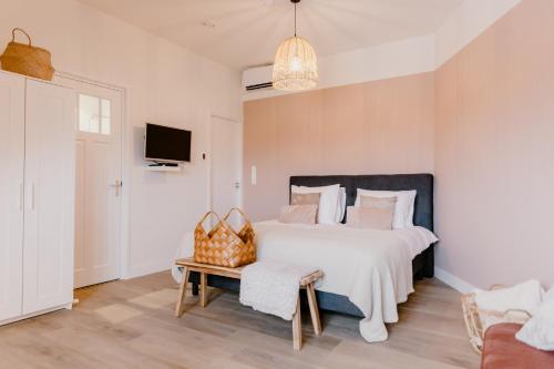 a bedroom with a large white bed and a couch at Millsight in Uitgeest
