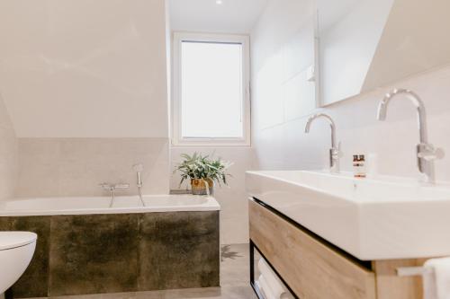 a bathroom with two sinks and a toilet and a window at Millsight in Uitgeest