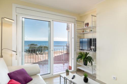 a living room with a couch and a large window at Hauzify I Apartament Cannes in Platja  d'Aro