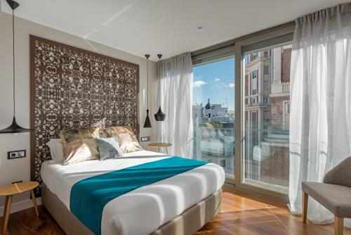 sypialnia z łóżkiem i dużym oknem w obiekcie Gran View Apartments w Madrycie