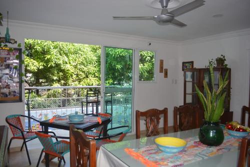 ein Esszimmer mit einem Tisch, Stühlen und einem Fenster in der Unterkunft Casa de Mony in Santa Marta