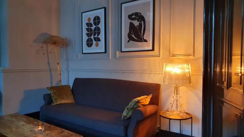 a living room with a blue couch and a lamp at Residenz Stadslogement in The Hague