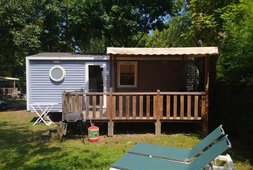 a tiny house with a porch and a deck at Mobile Homes by KelAir at Camping Sylvamar in Labenne