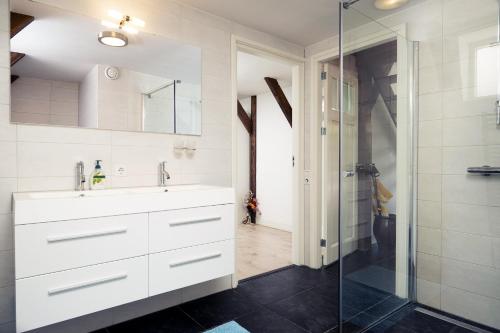 een badkamer met een witte wastafel en een douche bij Markermeerlogies in Bovenkarspel