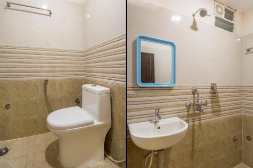 a bathroom with a toilet and a sink and a mirror at Hotel Siri Grand in Visakhapatnam