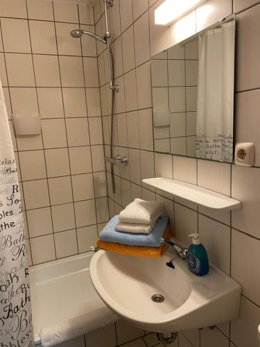 ein Badezimmer mit Waschbecken, Spiegel und Dusche in der Unterkunft Cafe Gaubenhaus in Bad Fallingbostel