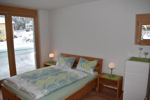 a bedroom with a bed with two lamps on tables at Curvér 3002 Ir Apart Irene in Lenz