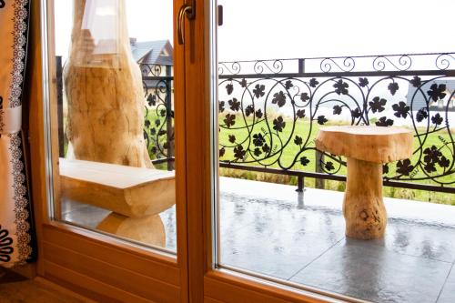 eine Glastür mit einer Bank auf dem Balkon in der Unterkunft Domki Pod Tatrami in Rzepiska