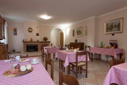 a restaurant with pink tables and chairs and a fireplace at Agriturismo La Panoramica in Assisi