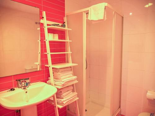 uma casa de banho com um lavatório e uma prateleira com toalhas em Kione Villamar em Alcossebre