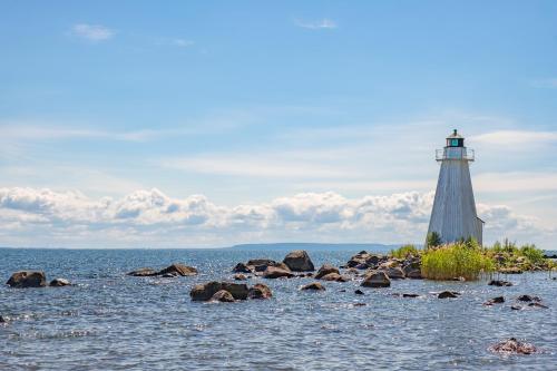 a lighthouse on the shore of a body of water at Hotell & Bistro Rödesund in Karlsborg