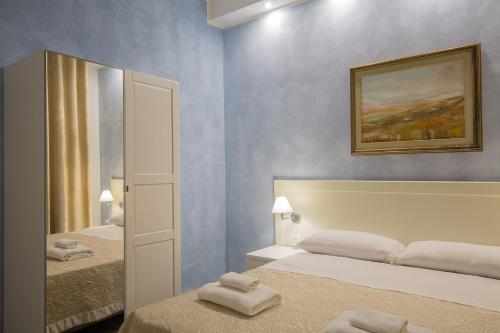 a hotel room with two beds and a mirror at Vela Rooms in Cagliari