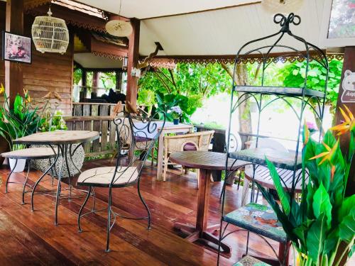 um restaurante com mesas e cadeiras num quarto em Sirilagoona Home Resort em Nong Prue