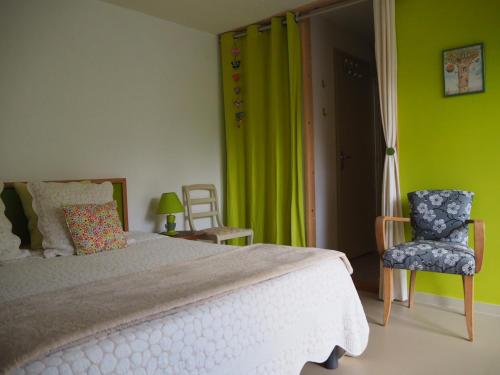 a bedroom with a bed and a green wall at Gîte des Pargo in Férel