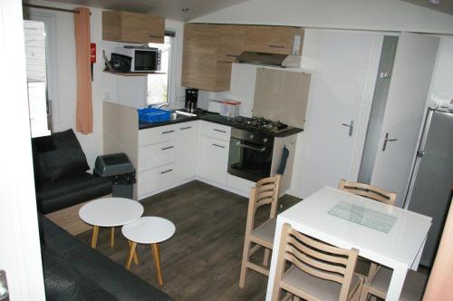 a small kitchen and dining room with a table and chairs at mobil home 32 m² 4/6p in Onzain