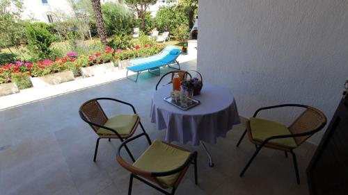 een tafel en stoelen op een patio met een tafel en stoelen bij Apartments Miro in Vantačići