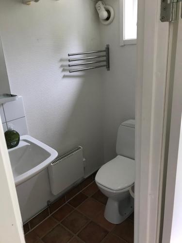 a white bathroom with a toilet and a sink at Hällestrand Seaview Apartment in Strömstad