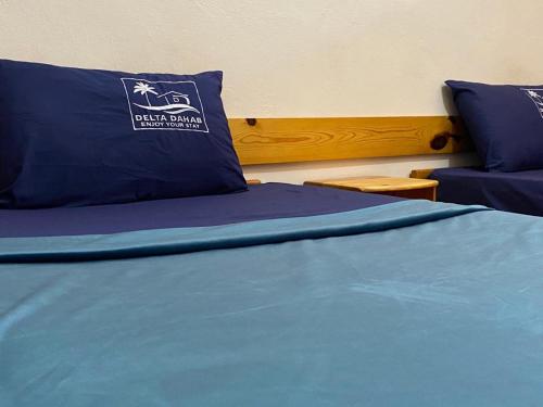 a bed with a blue comforter and a couch at Delta Dahab Hotel in Dahab