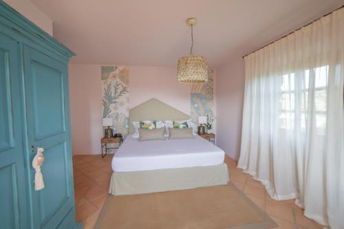 a bedroom with a bed and a blue door at Hotel Borgo Smeraldo in Arzachena