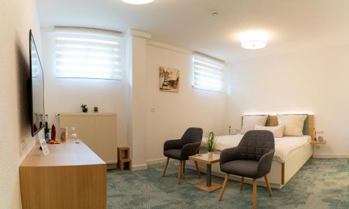 a hotel room with a bed and two chairs at Hotel zum Kuhhirten in Bremen