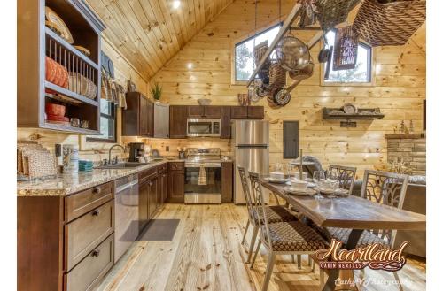 cocina con paredes de madera y mesa con sillas en Bear Bottom View, en Sevierville