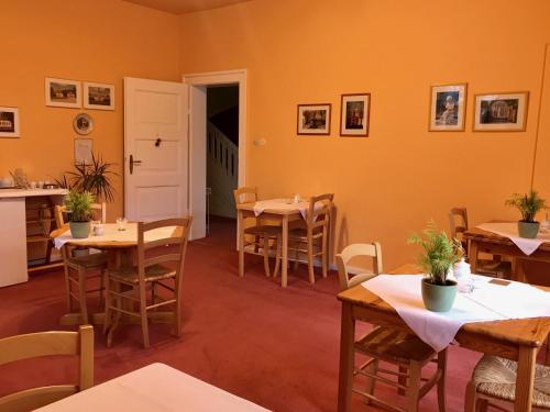 comedor con mesas, sillas y paredes de color naranja en Pension Villa Gisela, en Weimar
