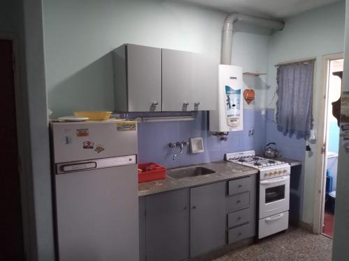 a small kitchen with a sink and a stove at Departamento 6 personas con vista al mar in Mar de Ajó