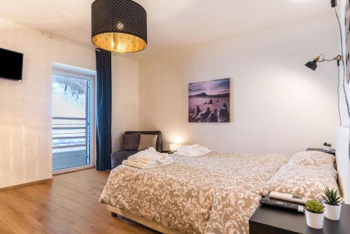 a bedroom with a bed and a chair and a window at Wellness Lodge Diletta in Santa Giuliana