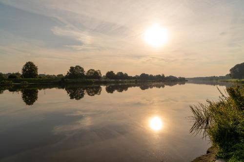 a view of a lake with the sun in the sky at Hotel zum Kuhhirten in Bremen