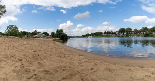 a sandy beach next to a body of water at Hotel zum Kuhhirten in Bremen