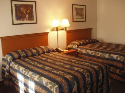 a hotel room with two beds and a telephone at Kozy Inn Columbus in Columbus
