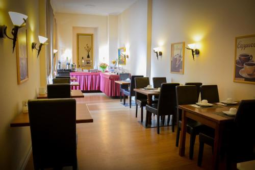 ヴィースバーデンにあるホテル アム ランデスハウスのテーブルと椅子、ピンクのカウンターがあるレストラン