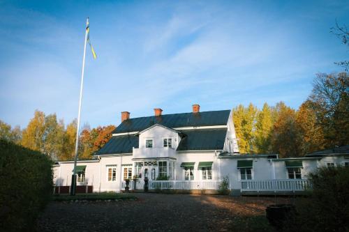 a large white house with a flag in front of it at Wanbo Herrgård in Nedre Vanbo