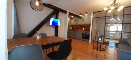 a dining room with a table and chairs and a kitchen at Old Town in Tarnów