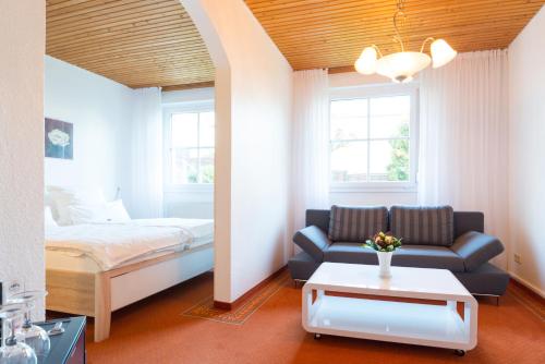un salon avec un lit et un canapé dans l'établissement Hotel zum Kuhhirten, à Brême