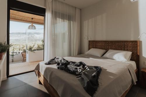 a bedroom with a large bed and a large window at Villa Panorama in Paleros