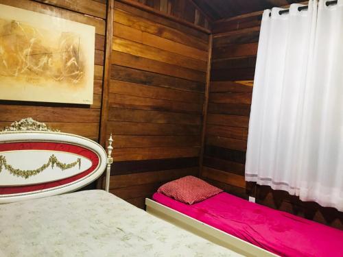 a small room with a bed and a curtain at Casa de Madeira com Fogão a Lenha lagoa no fundo para 8 pessoas in Morada Nova de Minas