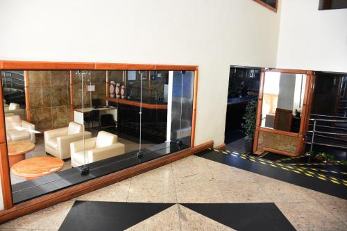 a lobby with a room with glass walls and furniture at Hotel Grão Para in Belém