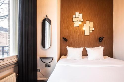 une chambre d'hôtel avec un lit et une fenêtre dans l'établissement Hotel V Frederiksplein, à Amsterdam