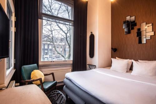 um quarto de hotel com uma cama e uma janela em Hotel V Frederiksplein em Amsterdã