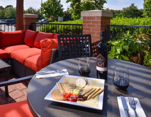 a table with a plate of food and a bottle of wine at Hyatt Place Garden City in Garden City