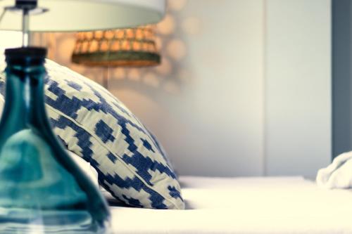 a blue vase sitting on a table next to a lamp at YOU & CO. Saler Beach Boutique in Valencia
