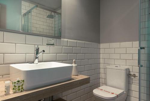 a white bathroom with a sink and a toilet at YOU & CO. Saler Beach Boutique in Valencia