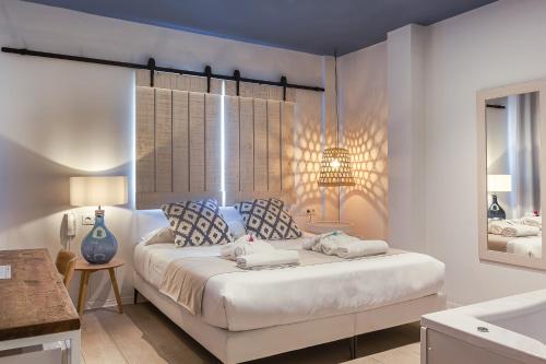 a bedroom with a large bed and a mirror at YOU & CO. Saler Beach Boutique in Valencia